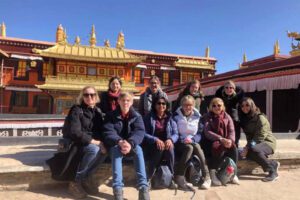 group of international tourists visiting golden roofed temple in tibet