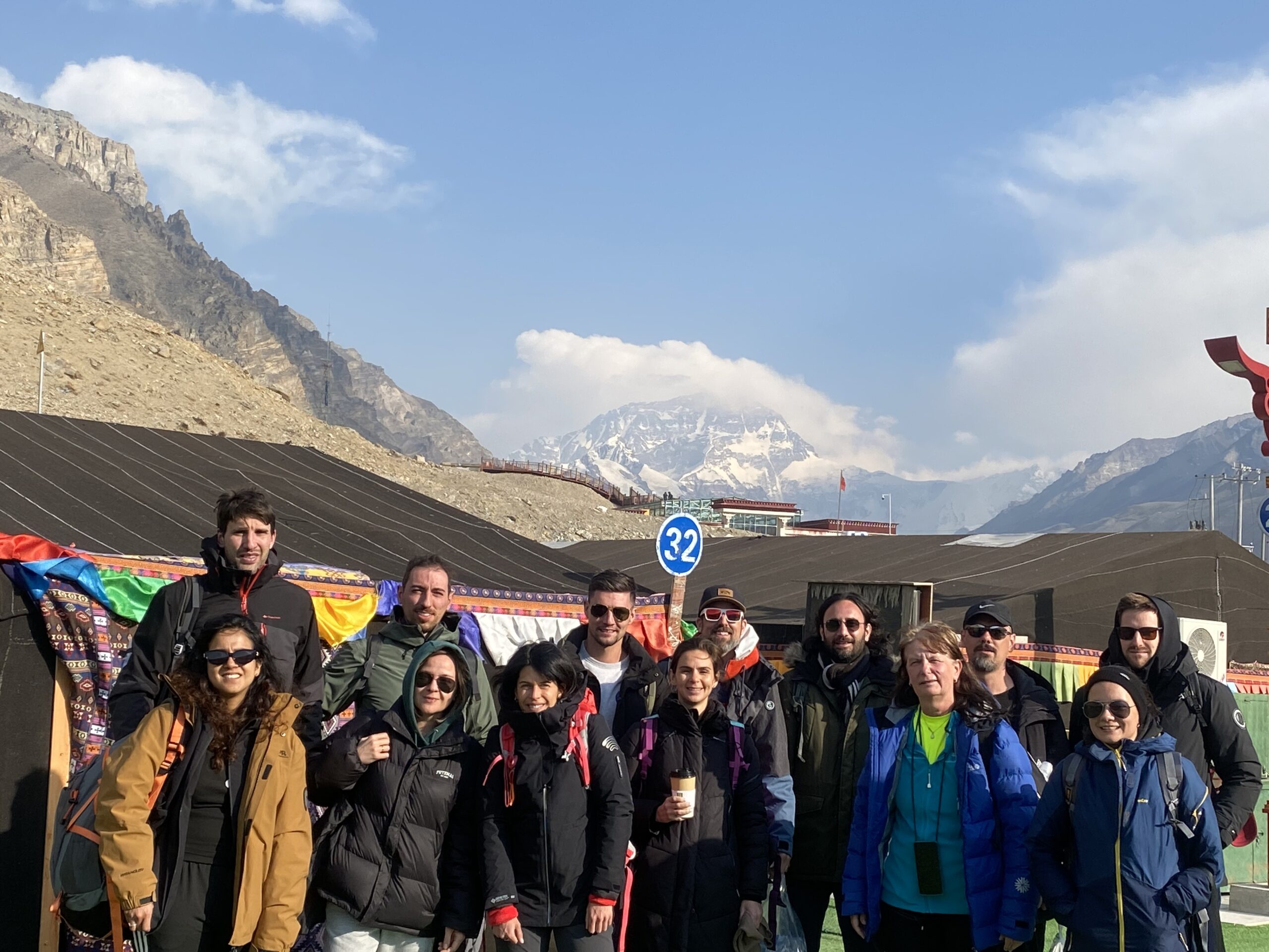Solo Travelers Group at High Altitude with Himalayan Views Solo travelers adventure group at high altitude with dramatic Himalayan snow-capped mountain views