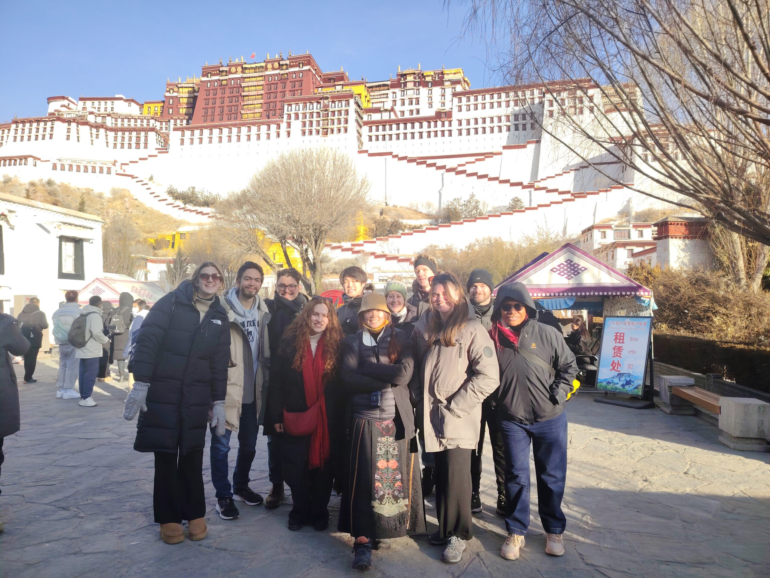 Solo Travelers Diverse Group at Potala Palace - Women and Men Diverse group of solo female and male travelers celebrating together at iconic Potala Palace Lhasa