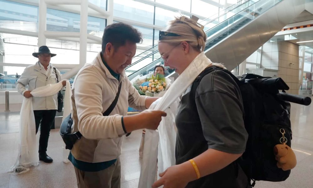 josie-receiving-tibetan-welcome-airport-cover